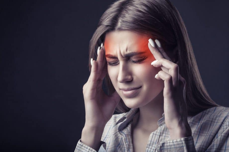 woman with headache rubbing temples