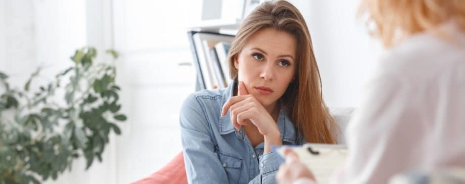 woman sitting on couch listening to doctor