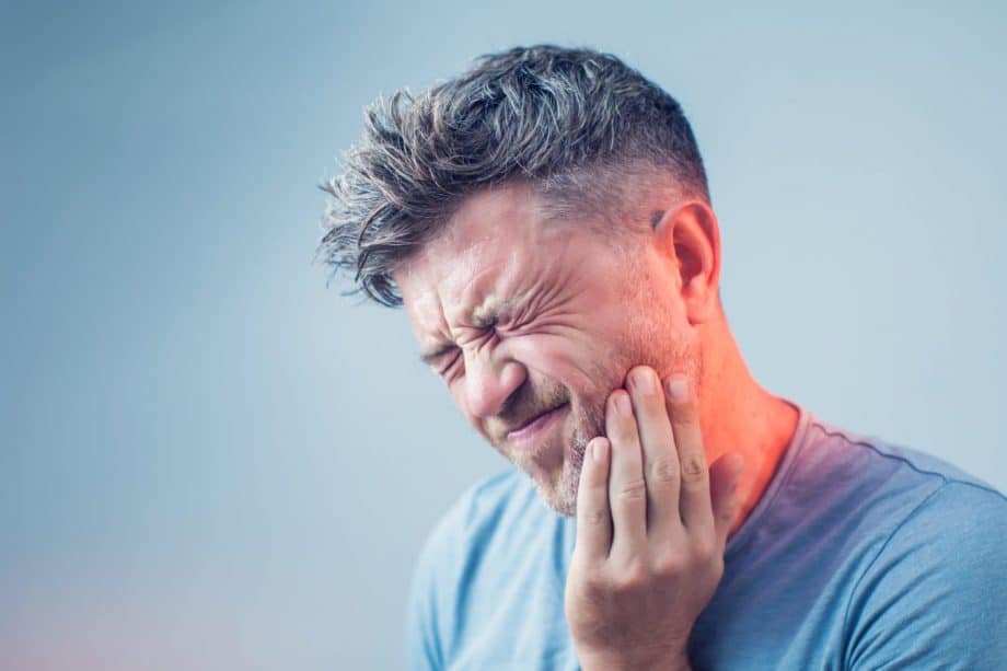 man holding jaw in pain