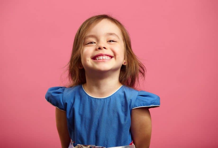 smiling toddler girl in blue dress