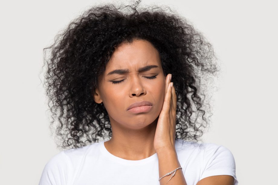 woman holding jaw in pain