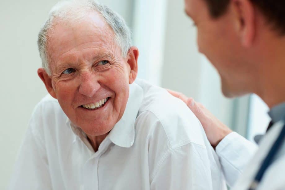 senior man smiling at dentist